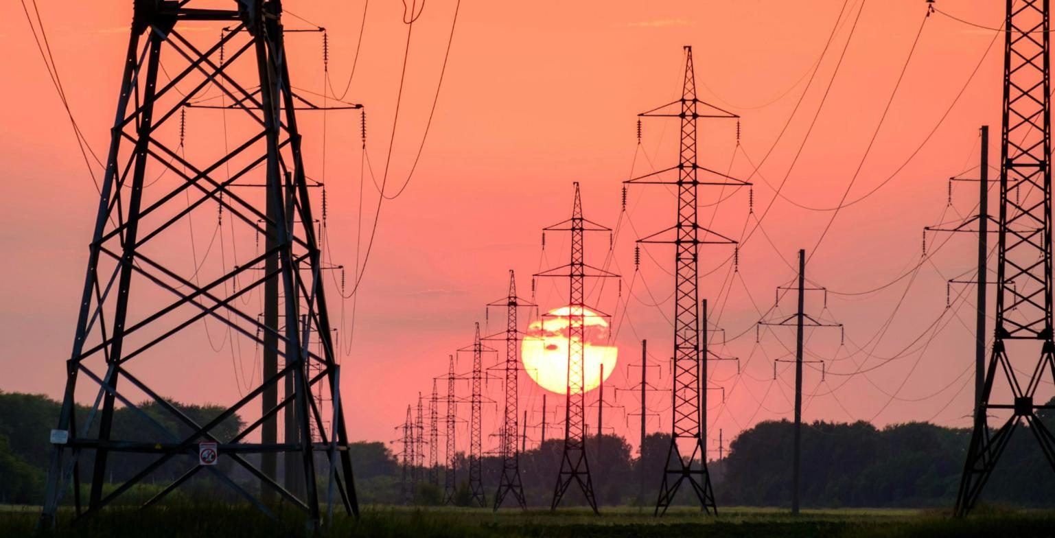 High voltage transmission towers at sunset